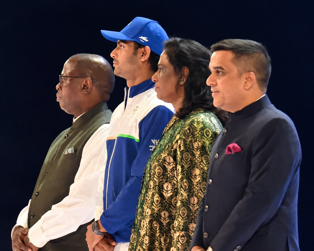 Neeraj Chopra, Dr. P. T. Usha and Harsh Sanghavi receive the Commonwealth Sport Flag during the Glasgow 2026 closing ceremony, marking the road to Amdavad 2030.