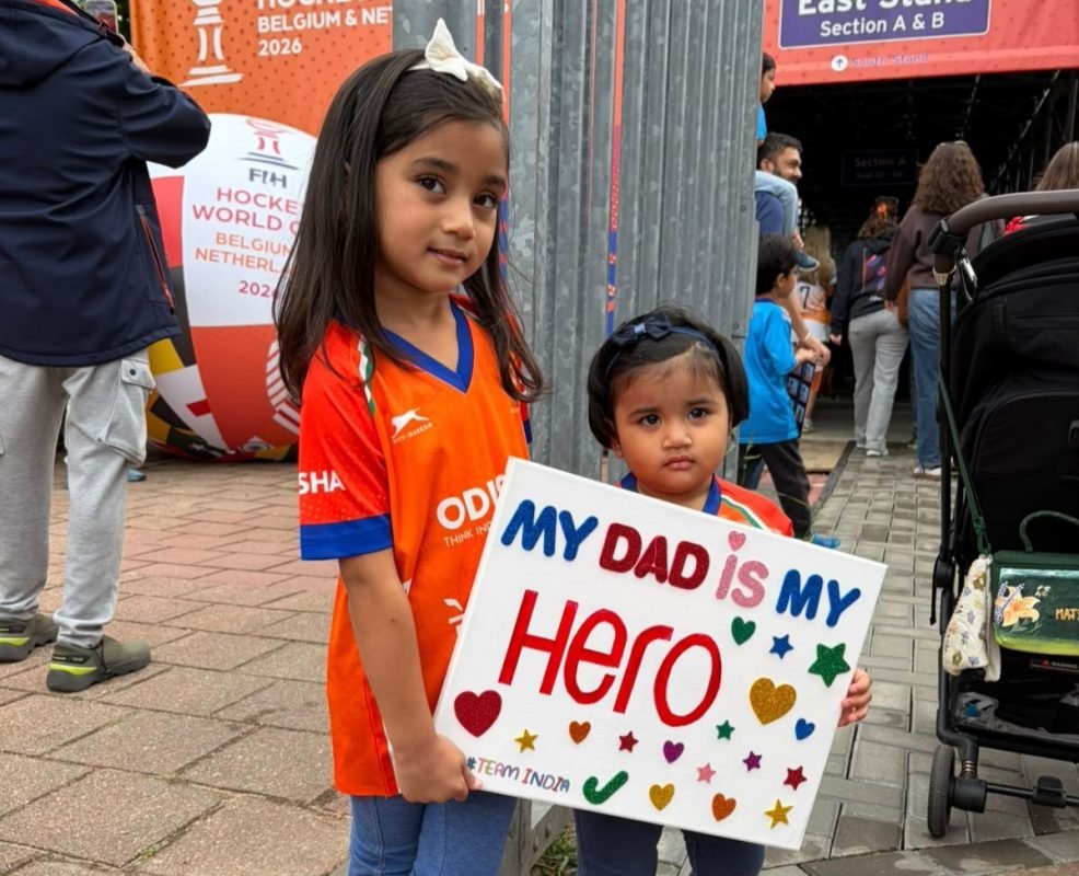 Manpreet Singh’s daughters cheering for their father with a “My Dad is My Hero” sign during a hockey match