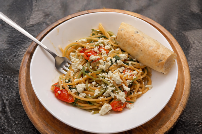 Healthy pasta recipe with spinach, cherry tomatoes and feta in a bowl